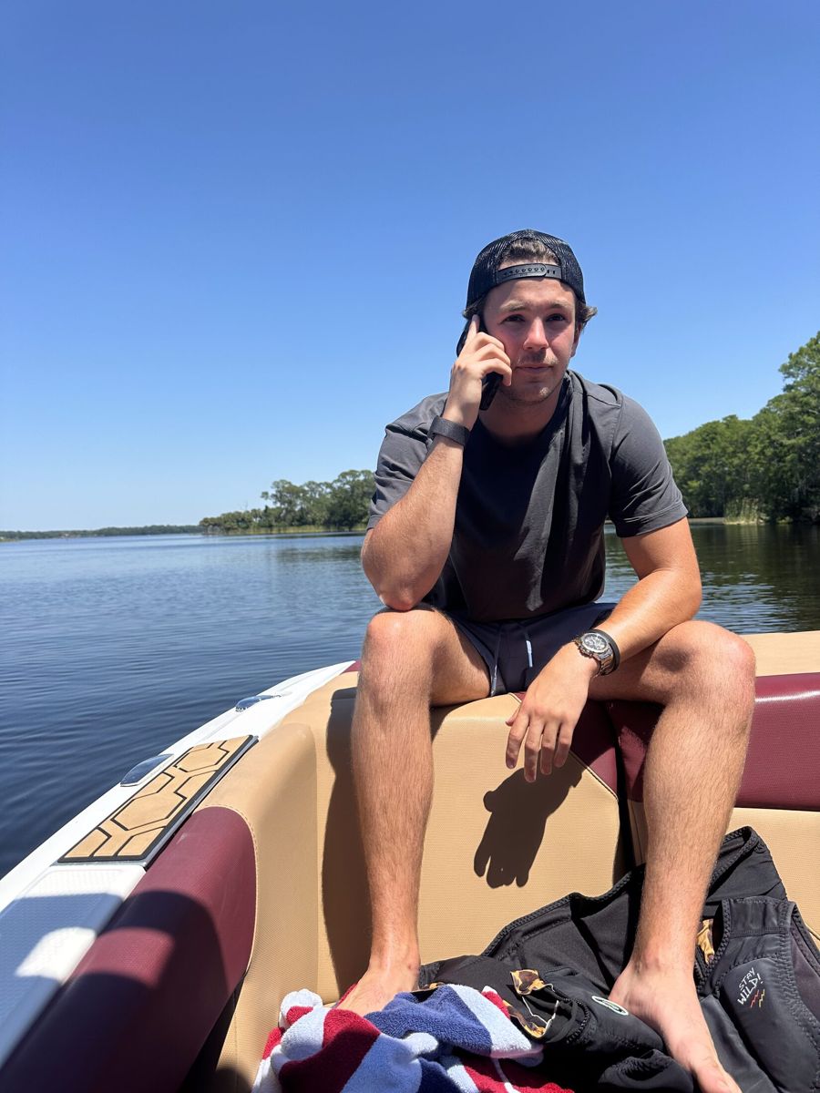 Carter on the phone on a boat